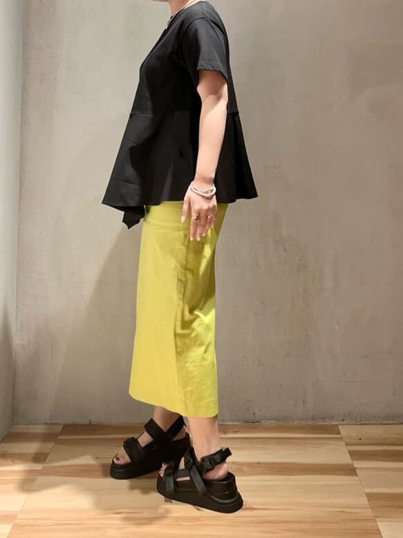 ブラック系のサンダル、イエロー系のスカート、ブラック系のTシャツ/カットソーを着用したレディースの夏コーディネートの3枚目の写真