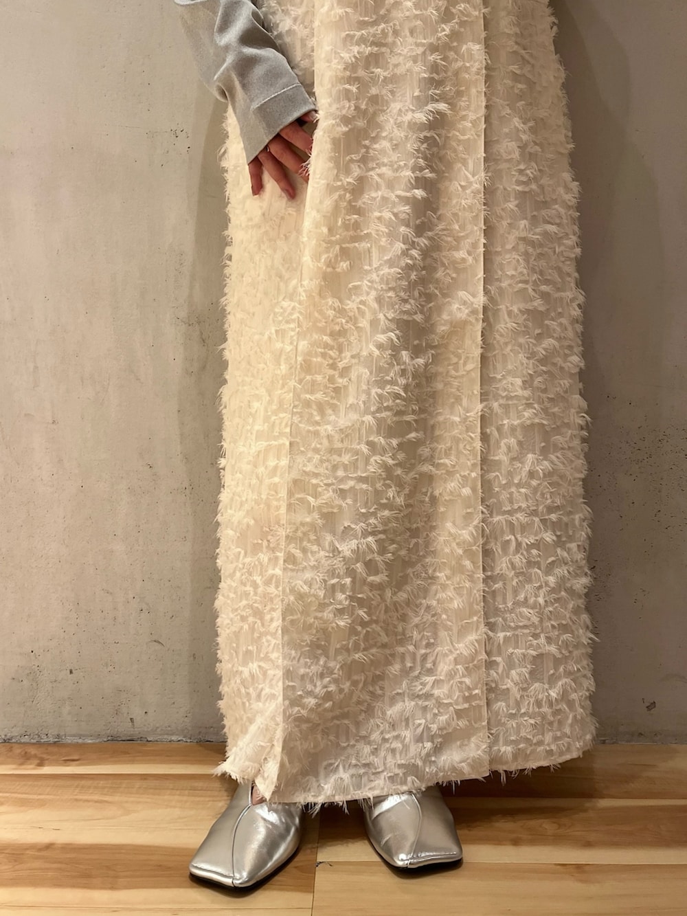 ホワイト系のワンピース、シルバー系のパンプス、シルバー系のニット/セーターを着用したレディースの冬コーディネートの8枚目の写真