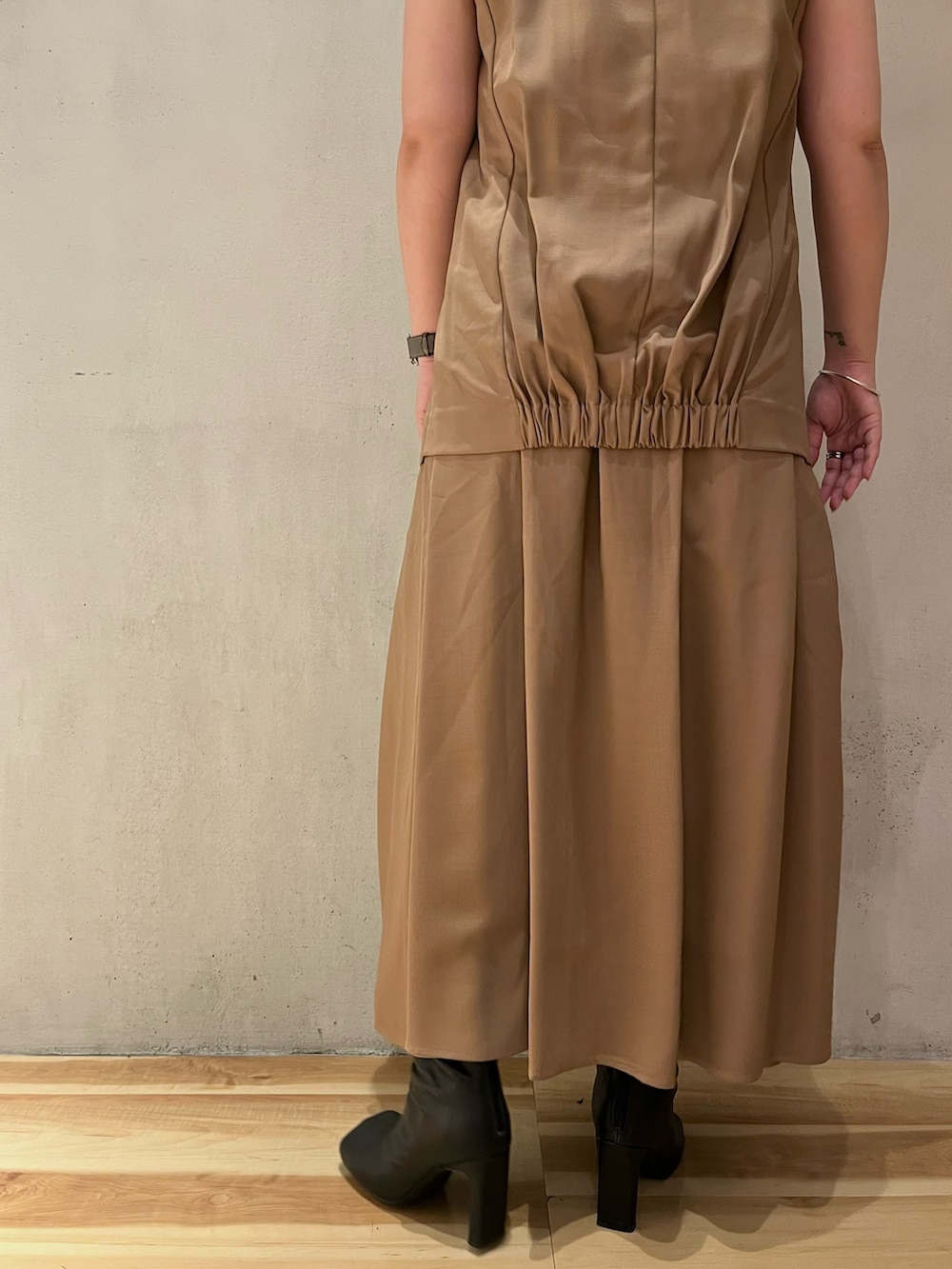 ベージュ系のワンピース、ブラック系のブーツ、ブラック系のキャップを着用したレディースの夏コーディネートの9枚目の写真