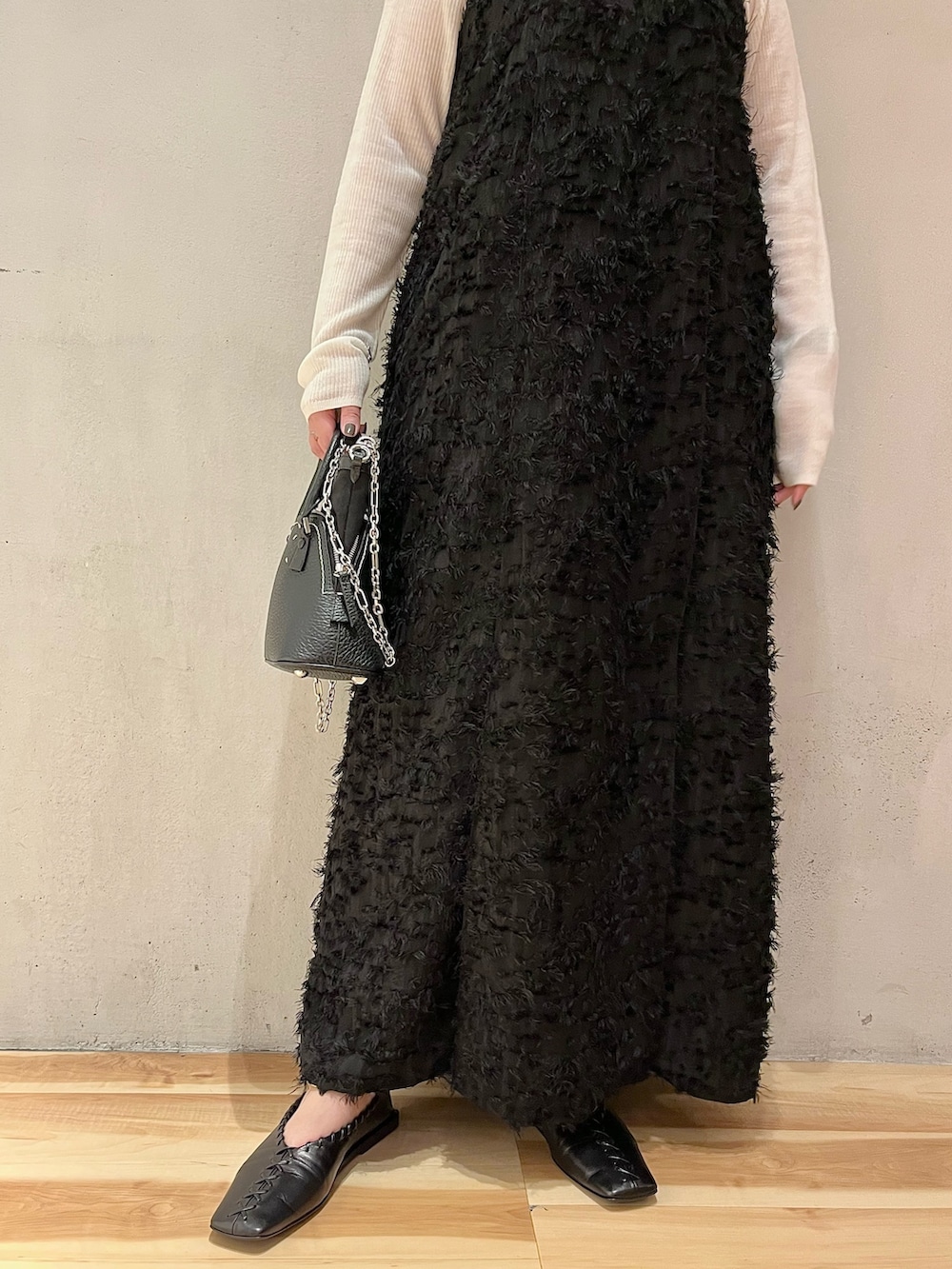 ブラック系のワンピース、ホワイト系のニット/セーターを着用したレディースの秋コーディネートの6枚目の写真