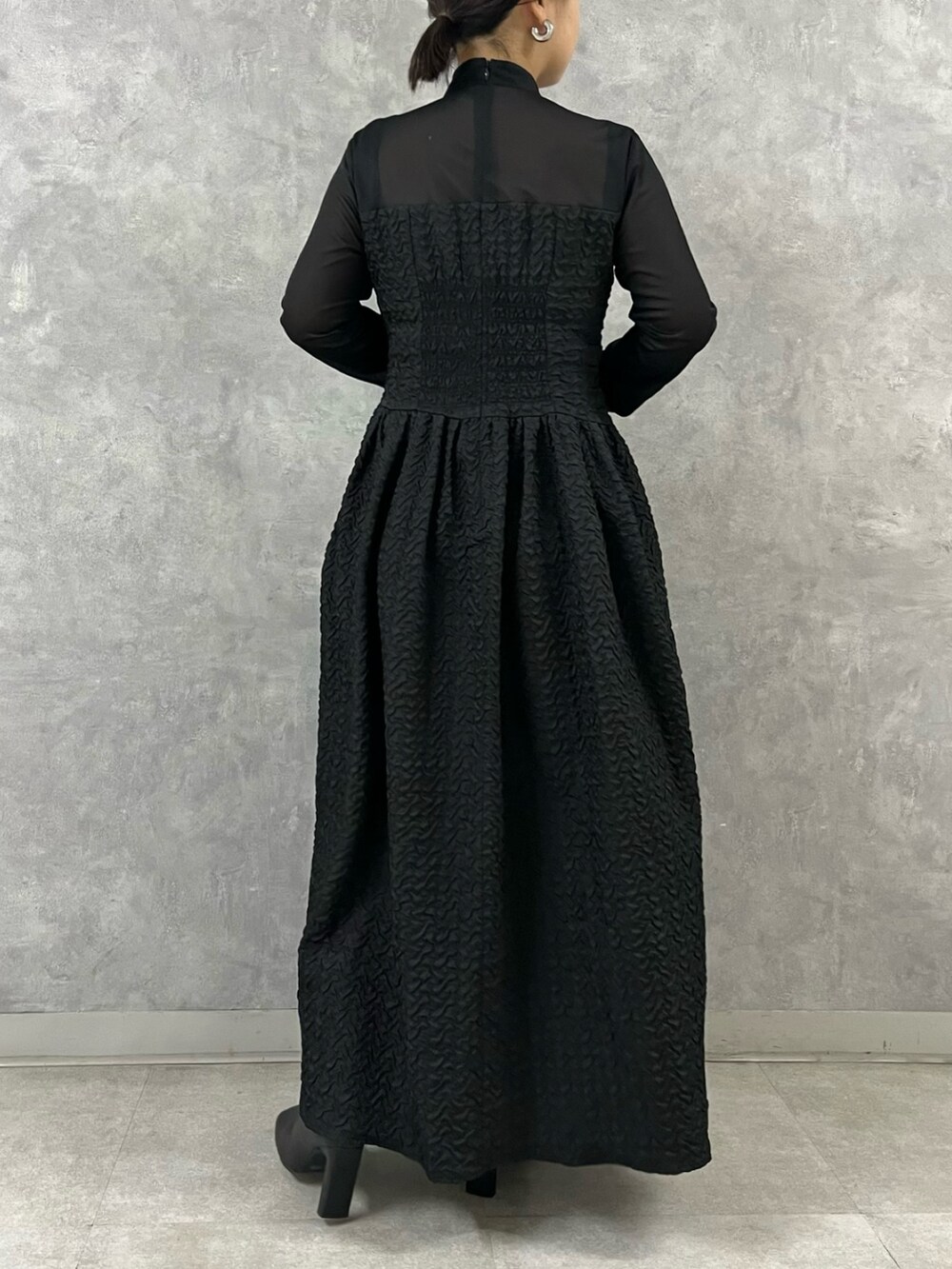 ブラック系のワンピース、ブラック系のブーツを着用したレディースの秋コーディネートの3枚目の写真