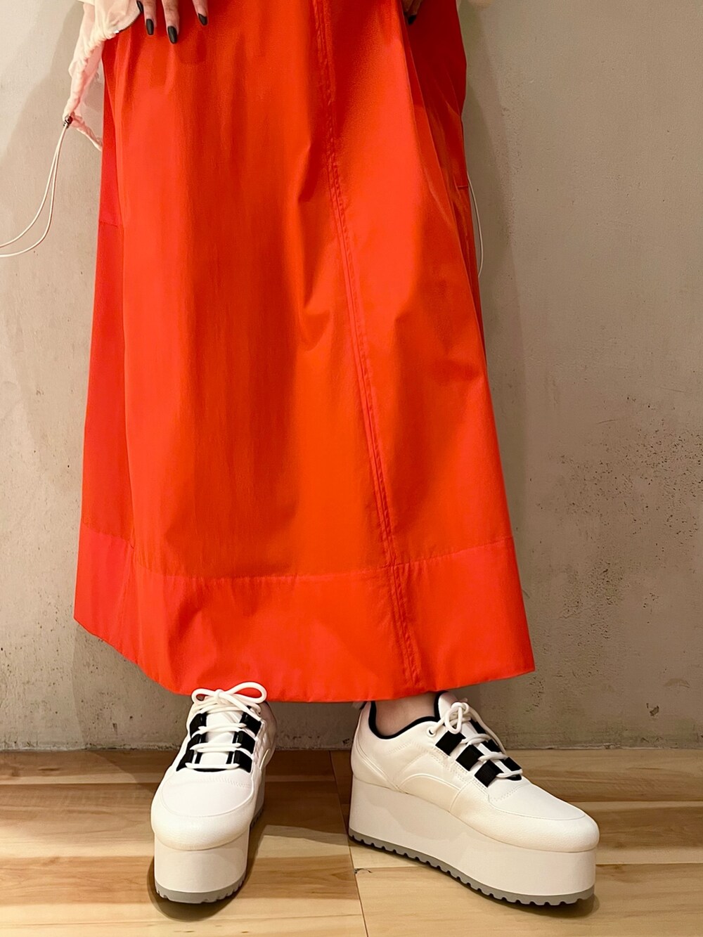 ホワイト系のブルゾン、レッド系のワンピース、ホワイト系のスニーカーを着用したレディースの夏コーディネートの6枚目の写真