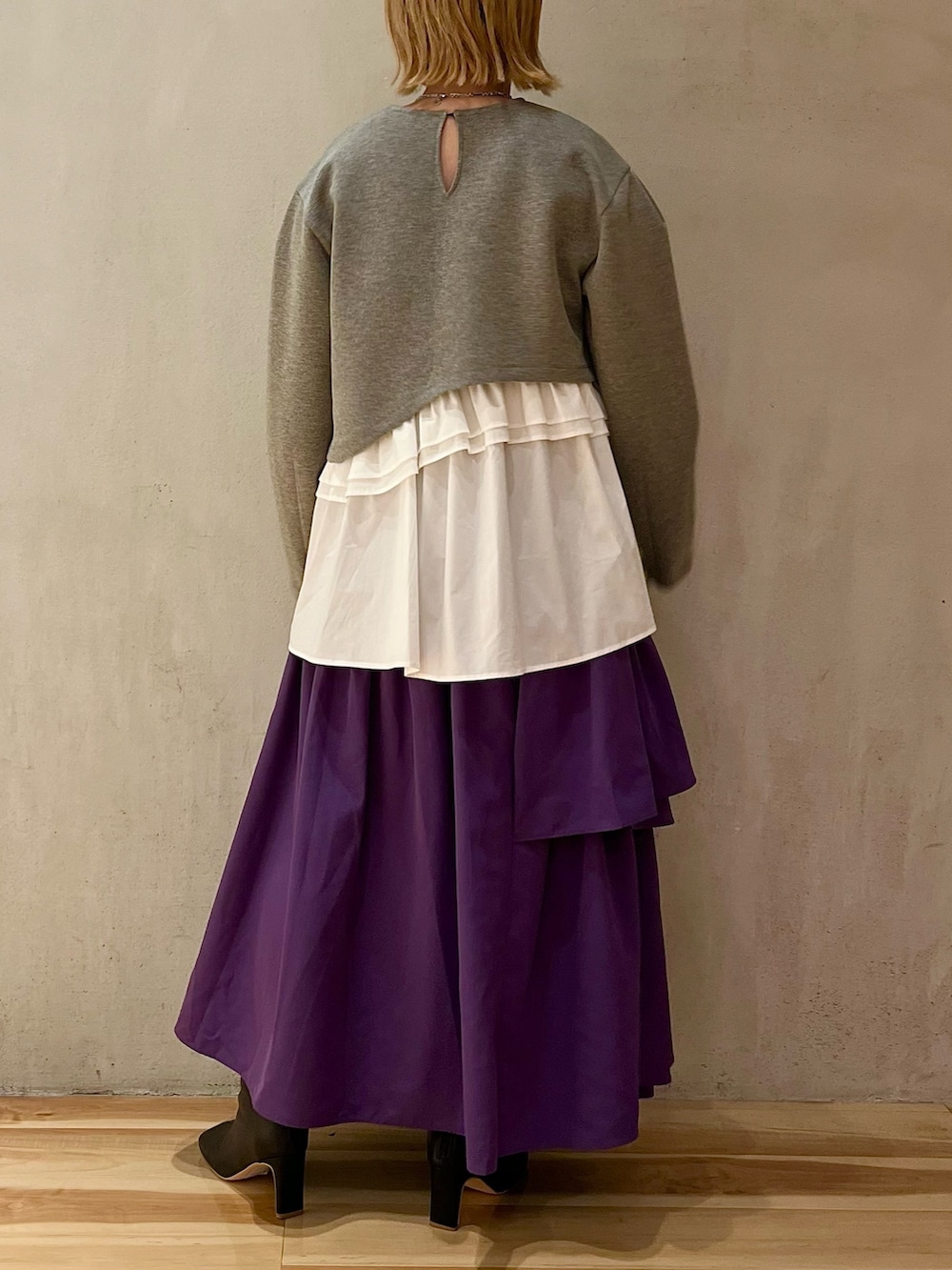 グレー系のTシャツ/カットソー、パープル系のスカート、ブラック系のブーツを着用したレディースの夏コーディネートの2枚目の写真