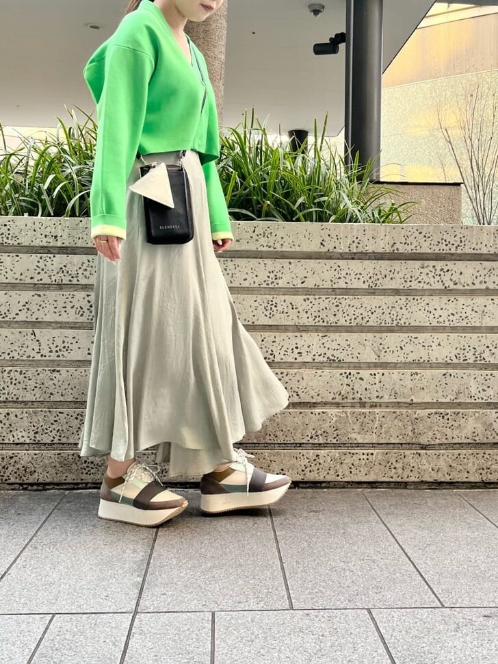 グリーン系のスニーカー、グリーン系のスカート、グリーン系のカーディガン/ボレロを着用したレディースの春コーディネートの3枚目の写真