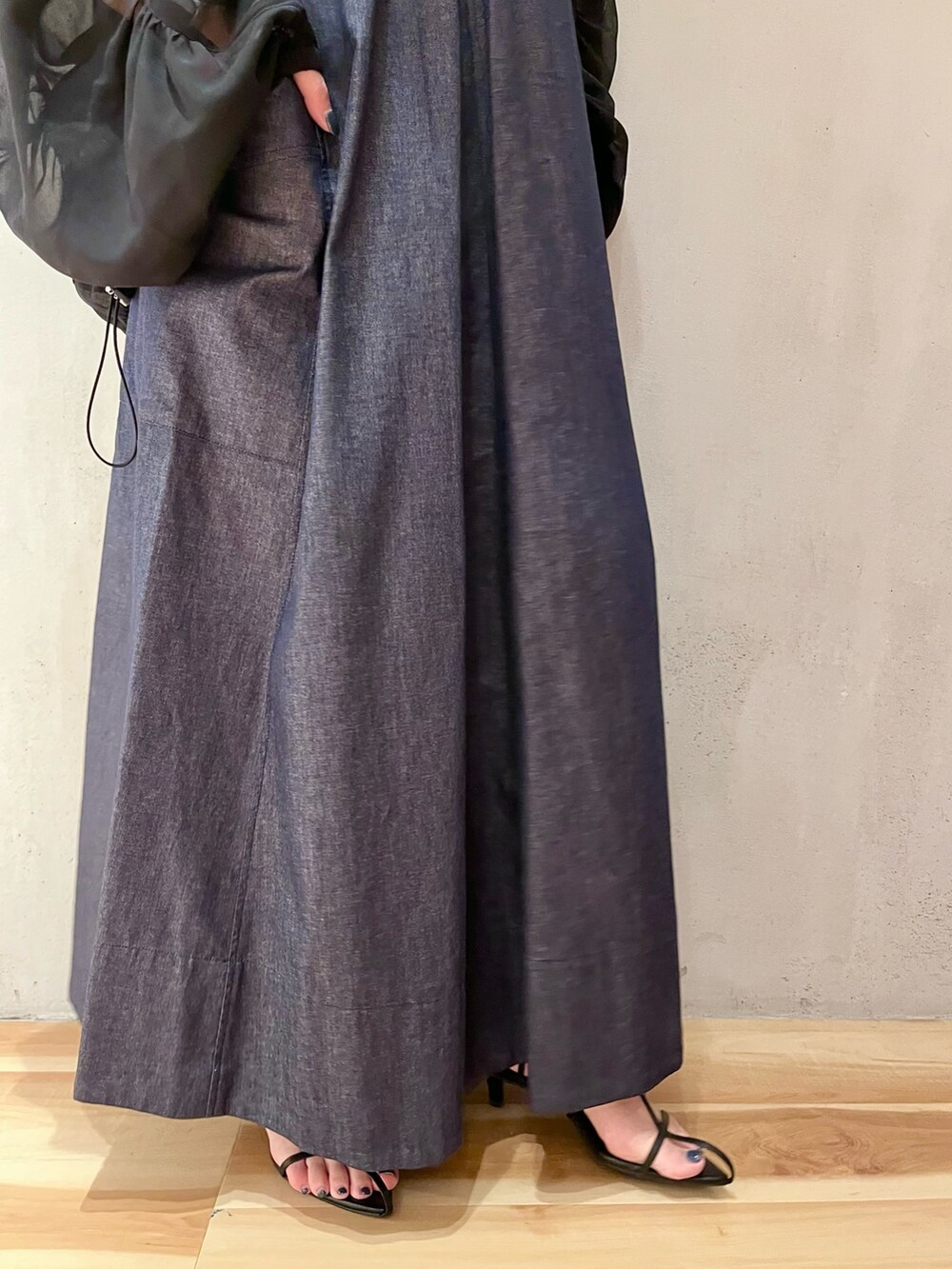 ブラック系のブルゾン、ブルー系のワンピース、ゴールド系のネックレスを着用したレディースの春コーディネートの7枚目の写真