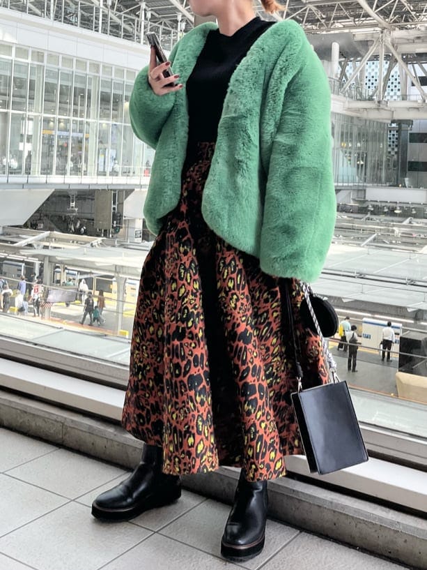 ブラック系のニット/セーター、ホワイト系のショルダーバッグ、グリーン系のノーカラーコートを着用したレディースの夏コーディネートの3枚目の写真