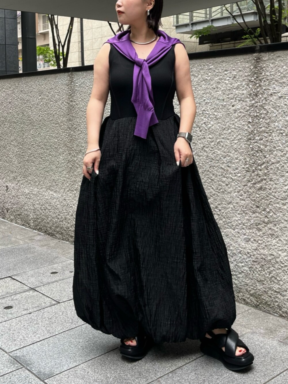 パープル系のカーディガン/ボレロ、ブラック系のサンダル、ブラック系のワンピースを着用したレディースの夏コーディネートの3枚目の写真