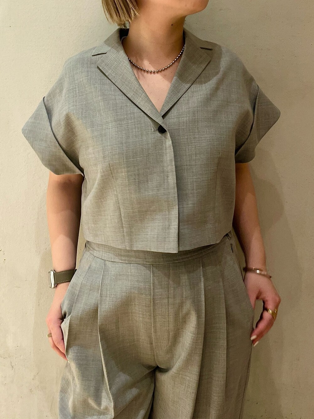 グレー系のテーラードジャケット、グレー系のスラックス、ブラック系のパンプスを着用したレディースの春コーディネートの5枚目の写真