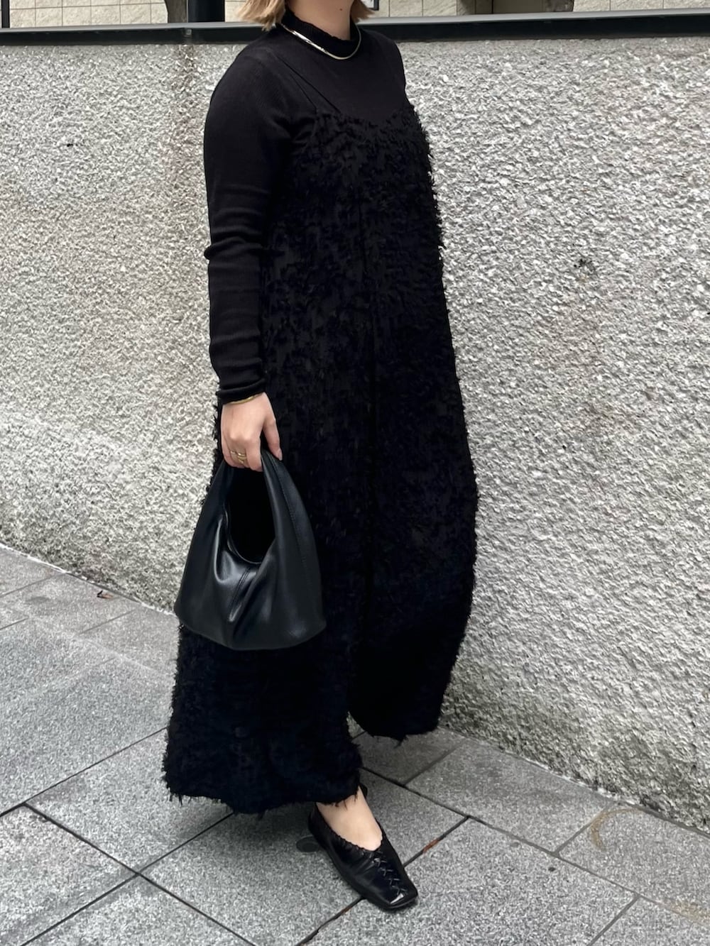 ブラック系のテーラードジャケット、ブラック系のニット/セーター、ブラック系のワンピースを着用したレディースの冬コーディネートの7枚目の写真