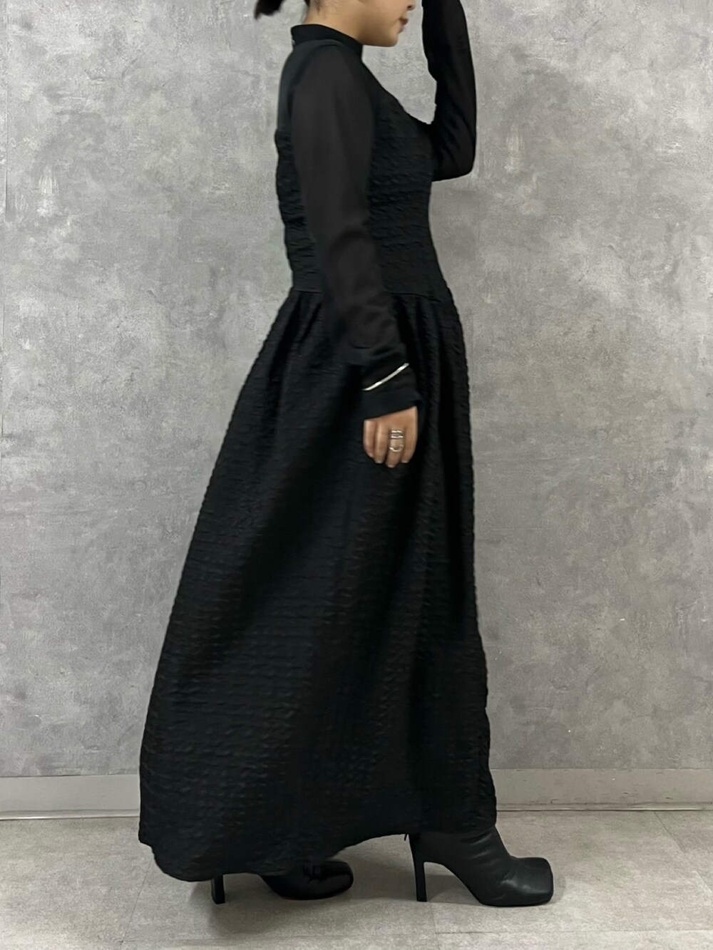 ブラック系のワンピース、ブラック系のブーツを着用したレディースの秋コーディネートの4枚目の写真