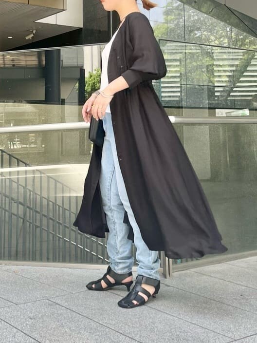 ホワイト系のキャミソール、ブラック系のワンピースを着用したレディースの春コーディネートの2枚目の写真