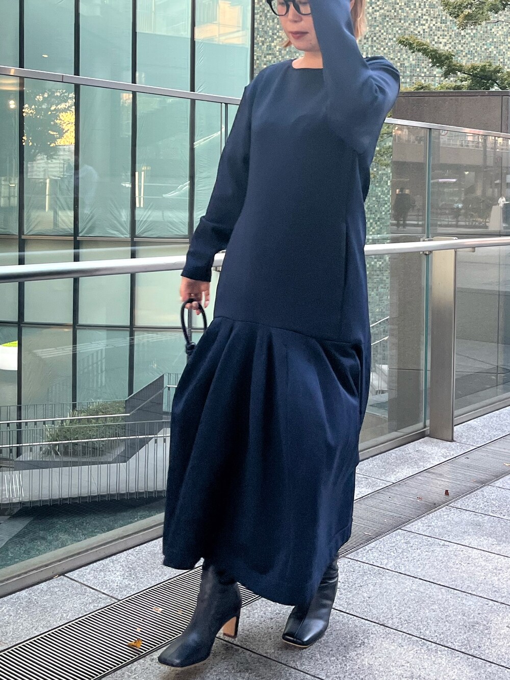 ブラック系のブーツ、ブルー系のワンピース、ベージュ系のハンドバッグを着用したレディースの秋コーディネートの8枚目の写真