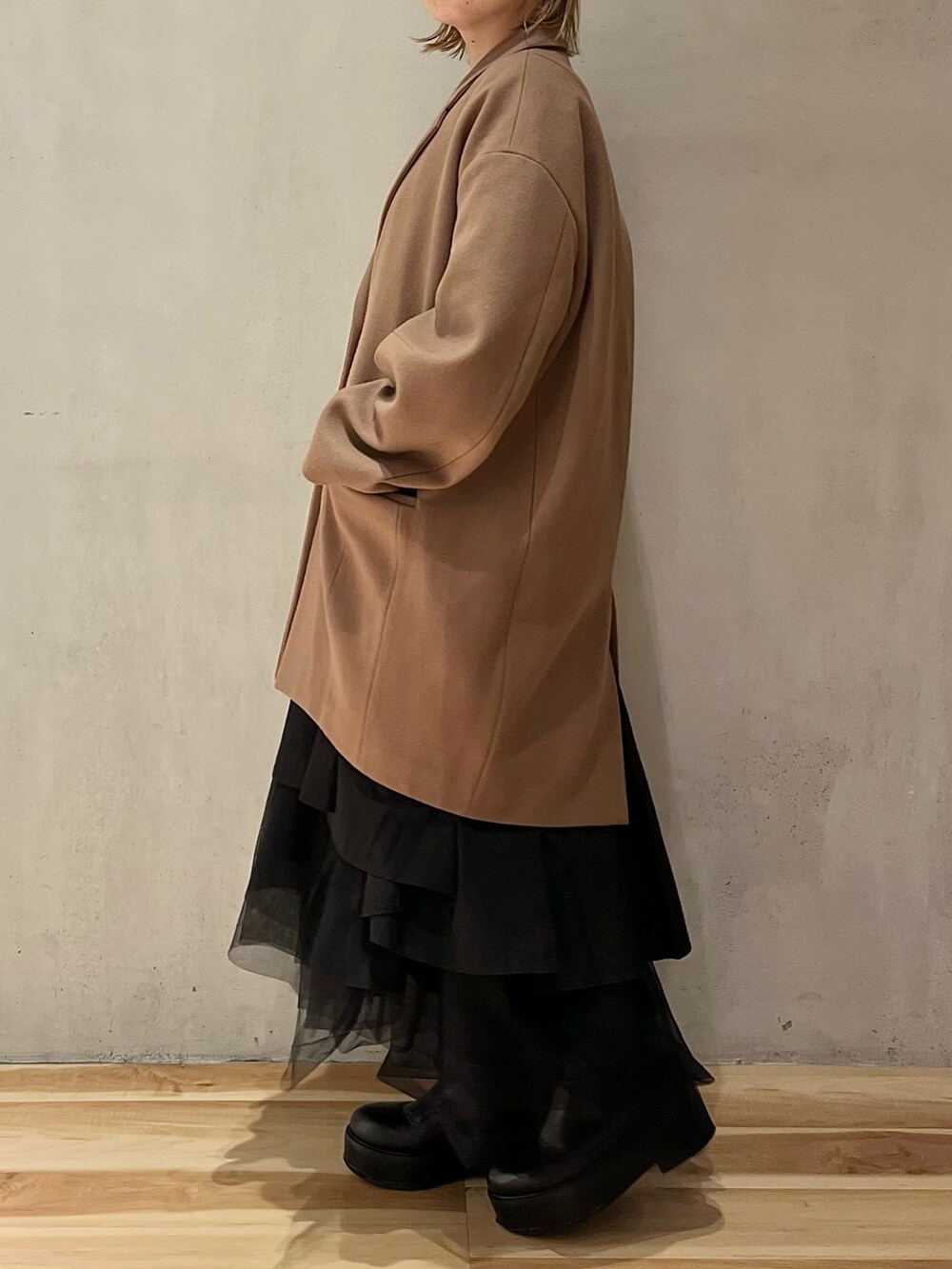 ブラック系のシャツ/ブラウス、ブラック系のスカート、ブラック系のブーツを着用したレディースの秋コーディネートの3枚目の写真