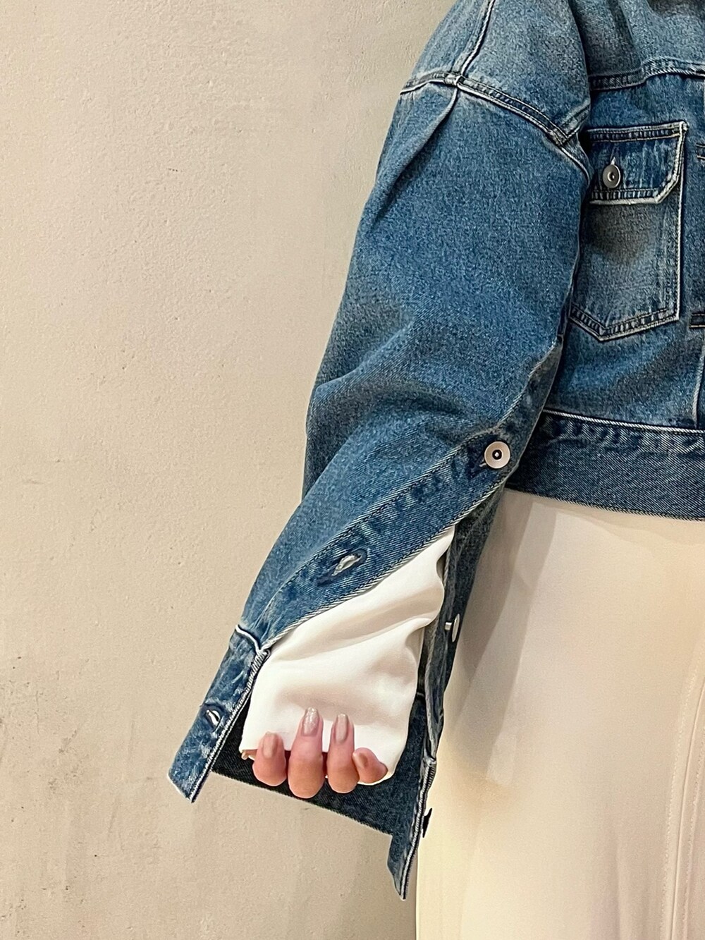 ブルー系のデニムジャケット、ホワイト系のワンピースを着用したレディースの冬コーディネートの7枚目の写真