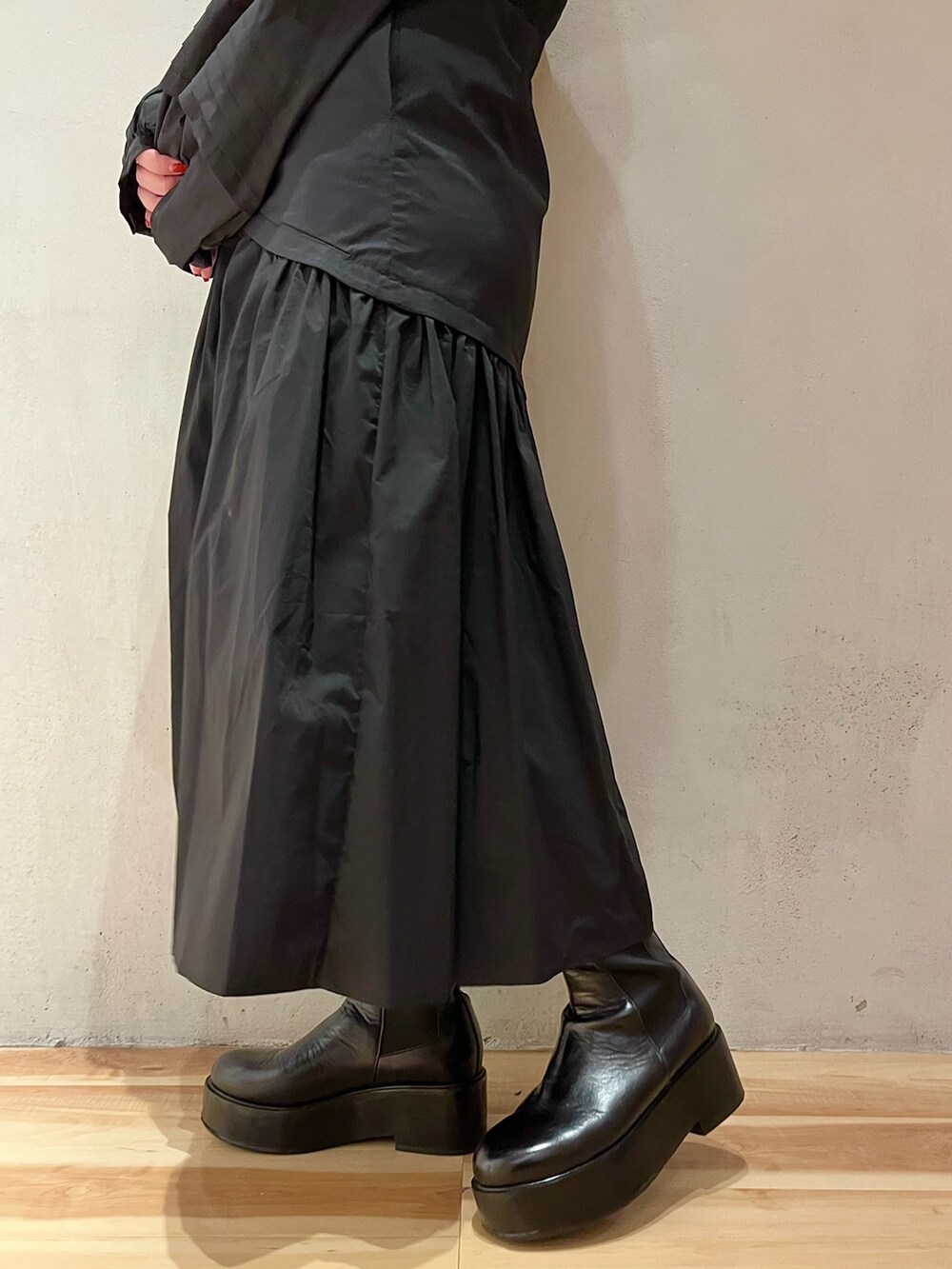 グリーン系のノーカラージャケット、ブラック系のワンピース、ブラック系のブーツを着用したレディースの秋コーディネートの10枚目の写真