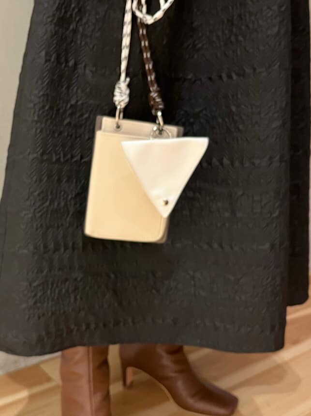 ベージュ系のショルダーバッグ、ブラウン系のブーツ、ブラック系のワンピースを着用したレディースの秋コーディネートの8枚目の写真