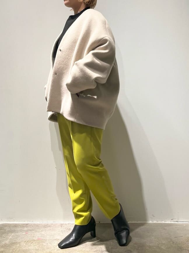 ブラック系のショルダーバッグ、グリーン系のその他パンツ、ベージュ系のノーカラーコートを着用したレディースの秋コーディネートの4枚目の写真