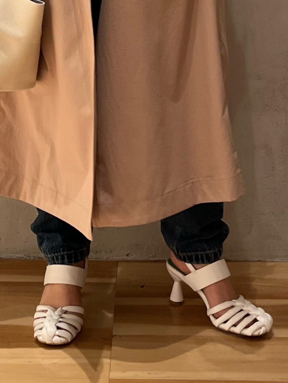 グリーン系のニット/セーター、ベージュ系のトレンチコート、ブルー系のデニムパンツを着用したレディースの冬コーディネートの9枚目の写真