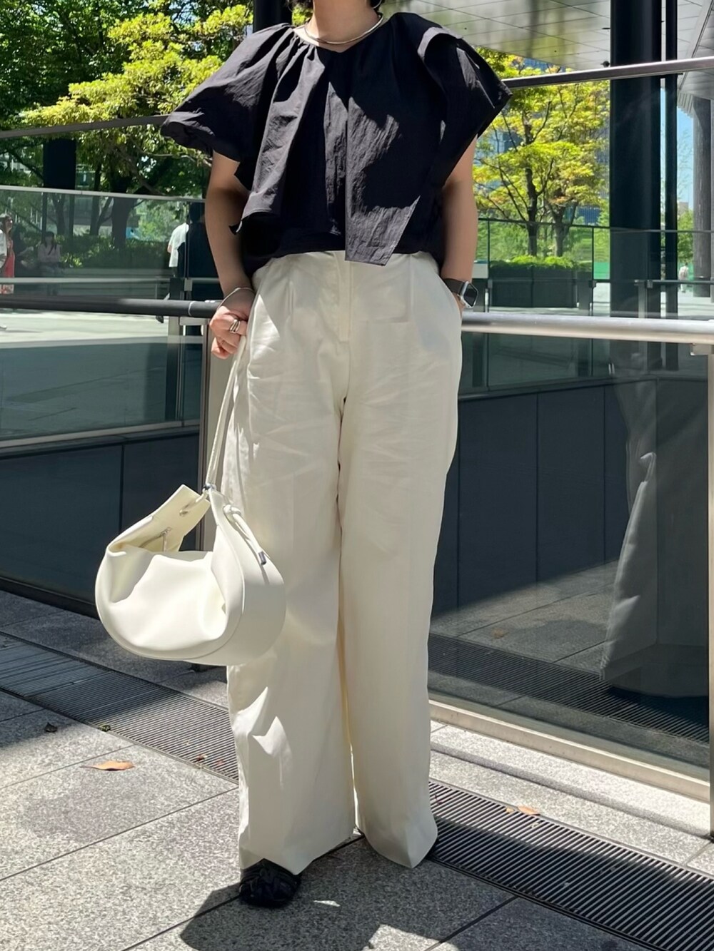 ブラック系のシャツ/ブラウス、ホワイト系のその他パンツ、ブラック系のサンダルを着用したレディースの春コーディネートの4枚目の写真