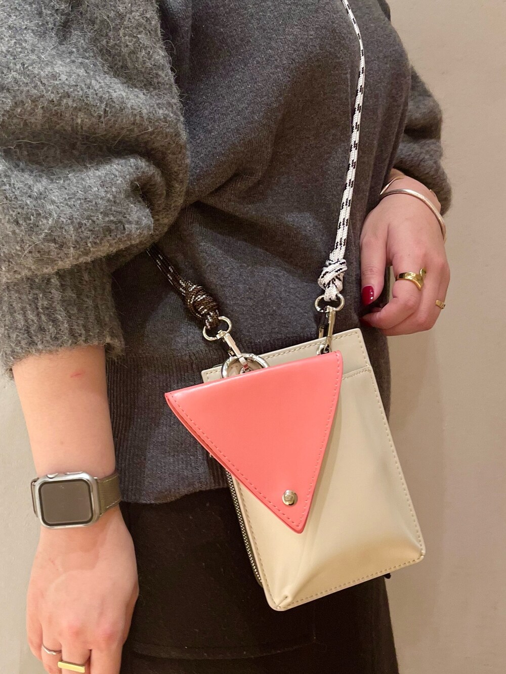 イエロー系のダウンジャケット/コート、グレー系のニット/セーター、ベージュ系のショルダーバッグを着用したレディースの冬コーディネートの9枚目の写真