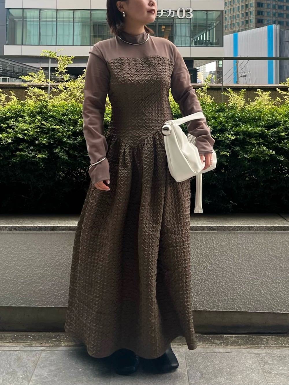 パープル系のカーディガン/ボレロ、ホワイト系のハンドバッグ、ベージュ系のワンピースを着用したレディースの夏コーディネートの6枚目の写真