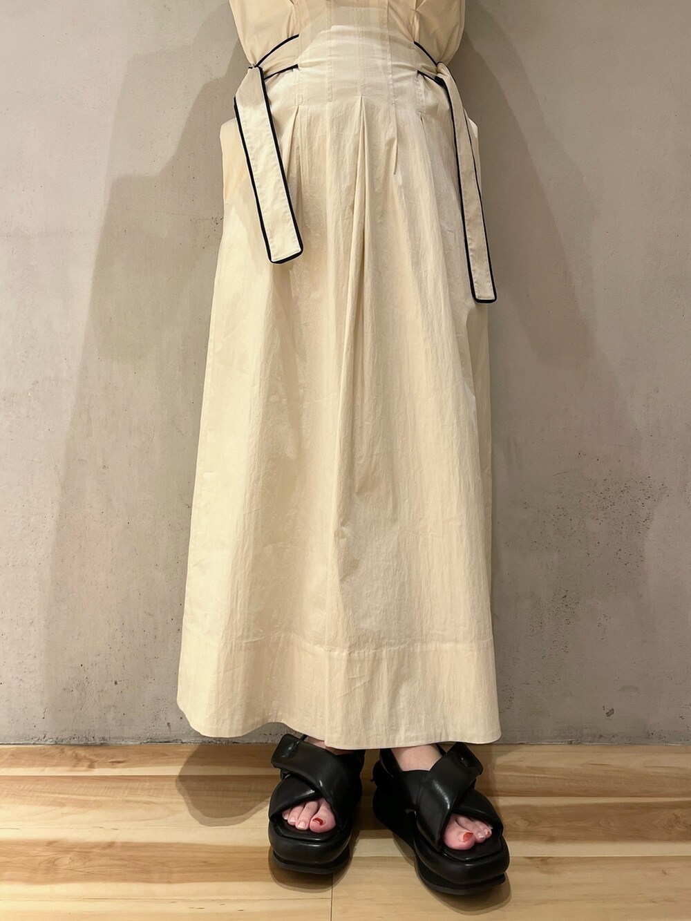 ホワイト系のワンピース、ブラック系のサンダルを着用したレディースの冬コーディネートの6枚目の写真