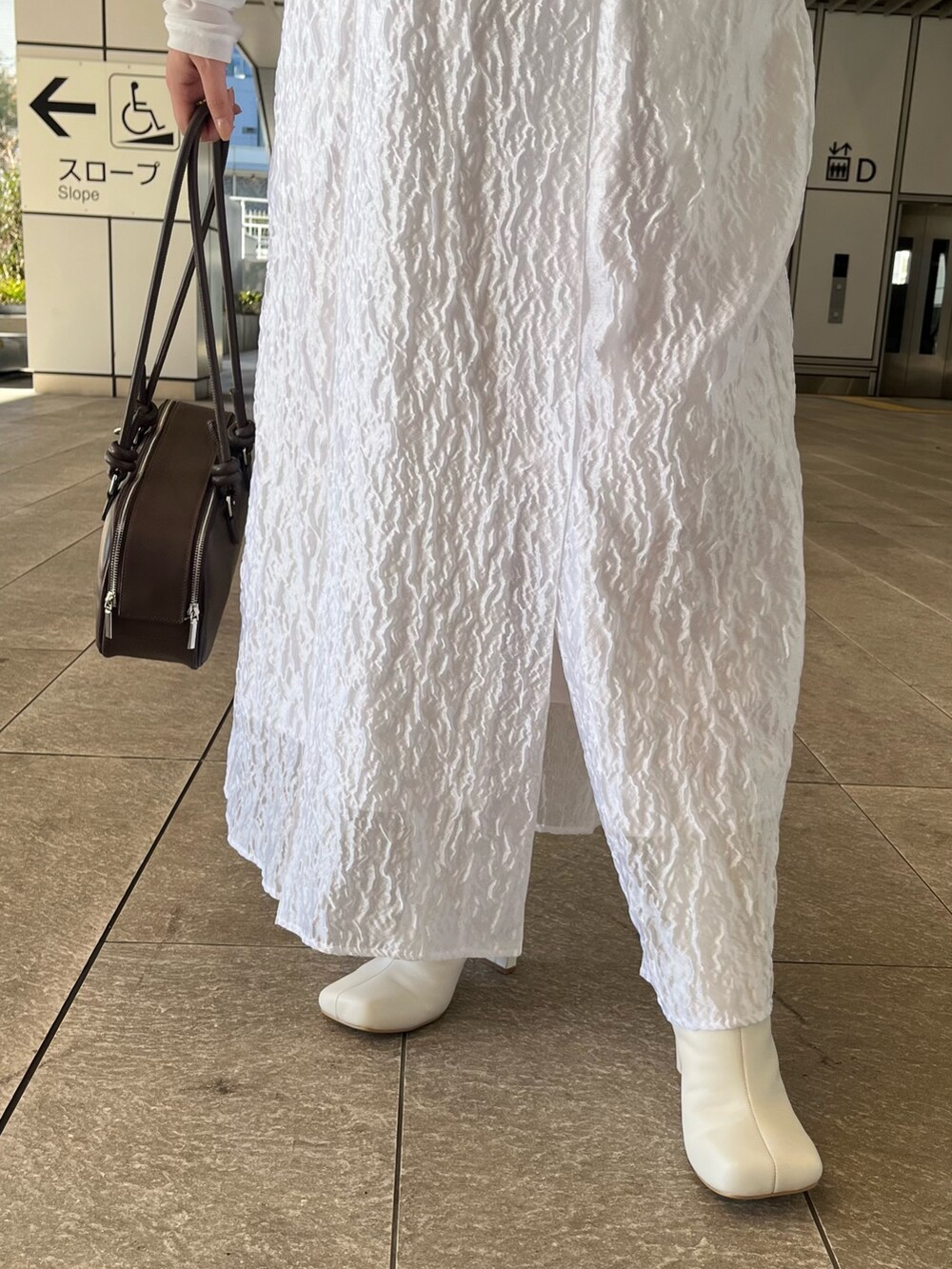 ホワイト系のTシャツ/カットソー、ホワイト系のワンピース、ホワイト系のブーツを着用したレディースの冬コーディネートの10枚目の写真