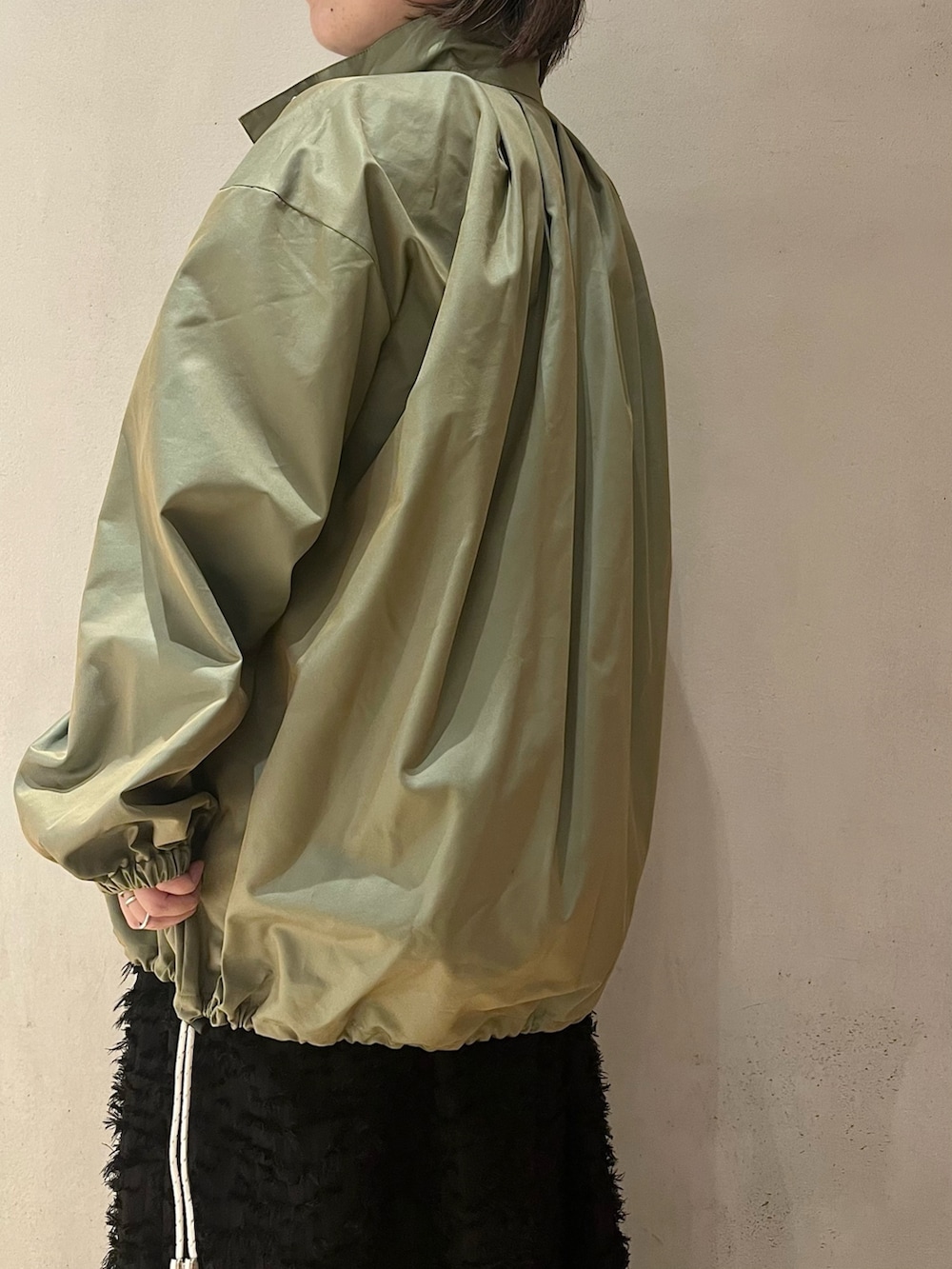 グリーン系のミリタリージャケット、ブラック系のワンピースを着用したレディースの春コーディネートの8枚目の写真