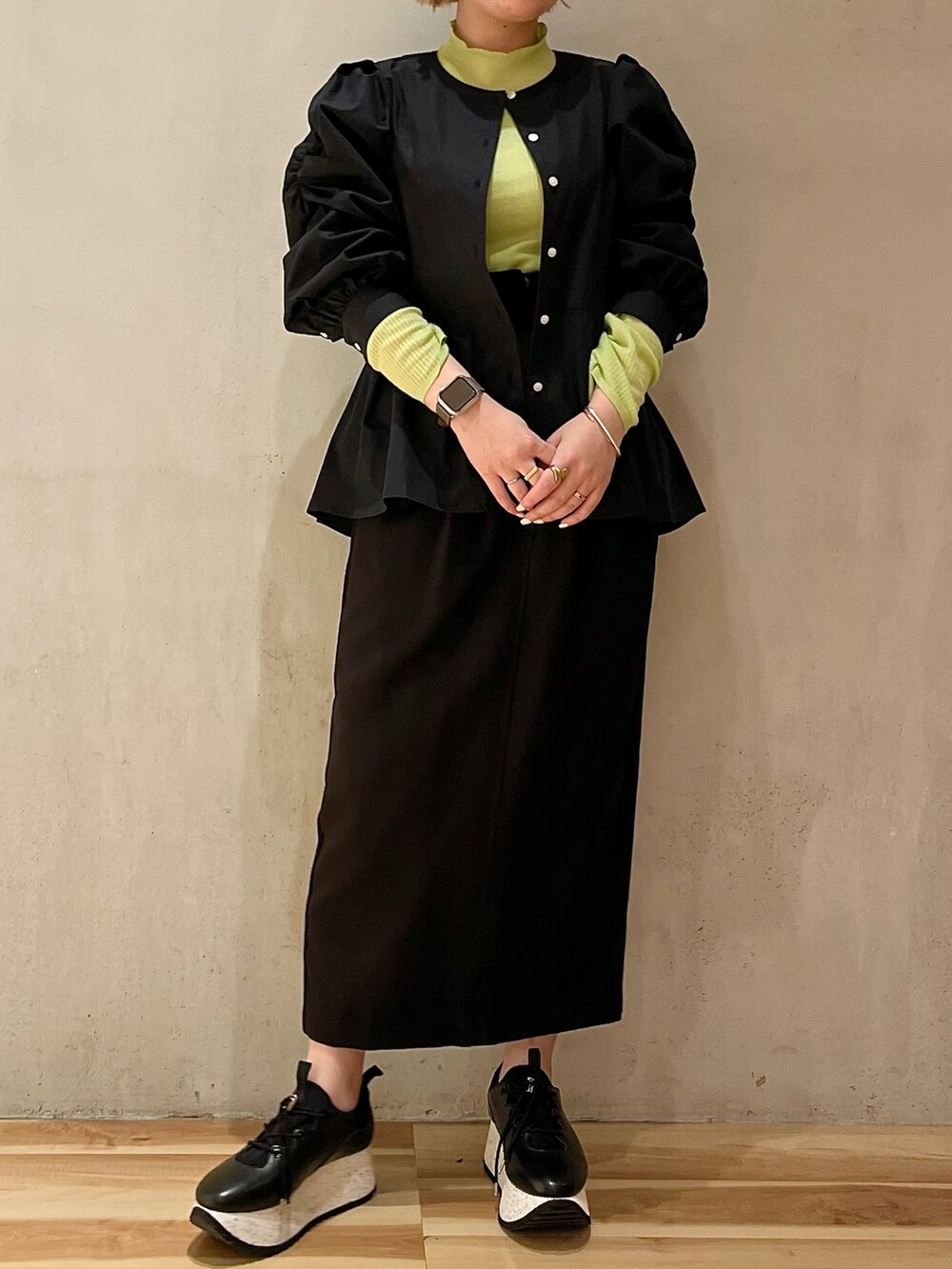 ブラック系のシャツ/ブラウス、グリーン系のニット/セーター、ブラック系のスカートを着用したレディースの冬コーディネートの4枚目の写真