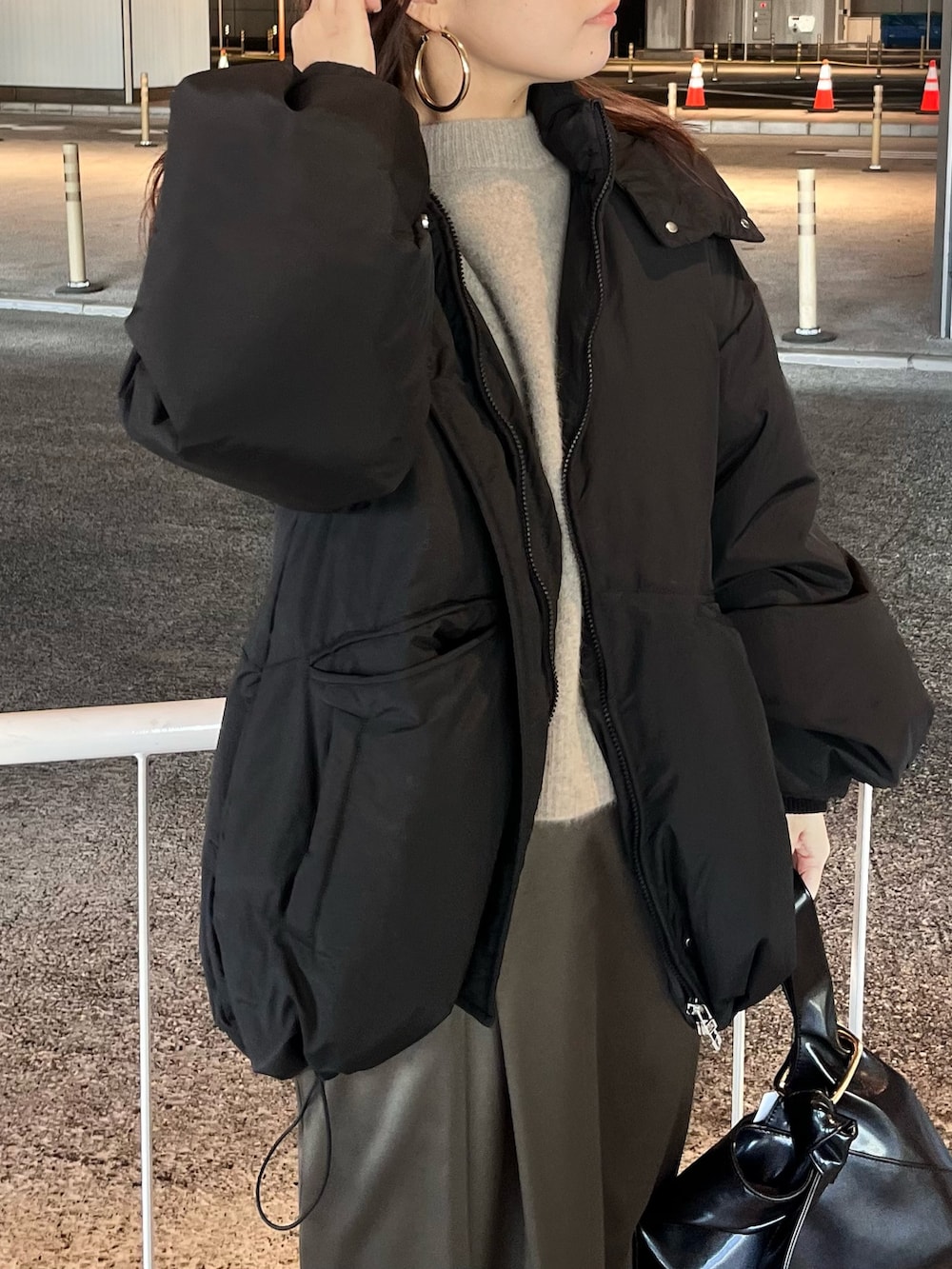 ブラック系のダウンジャケット/コート、ブラウン系のニット/セーター、ブラウン系のスカートを着用したレディースの冬コーディネートの7枚目の写真