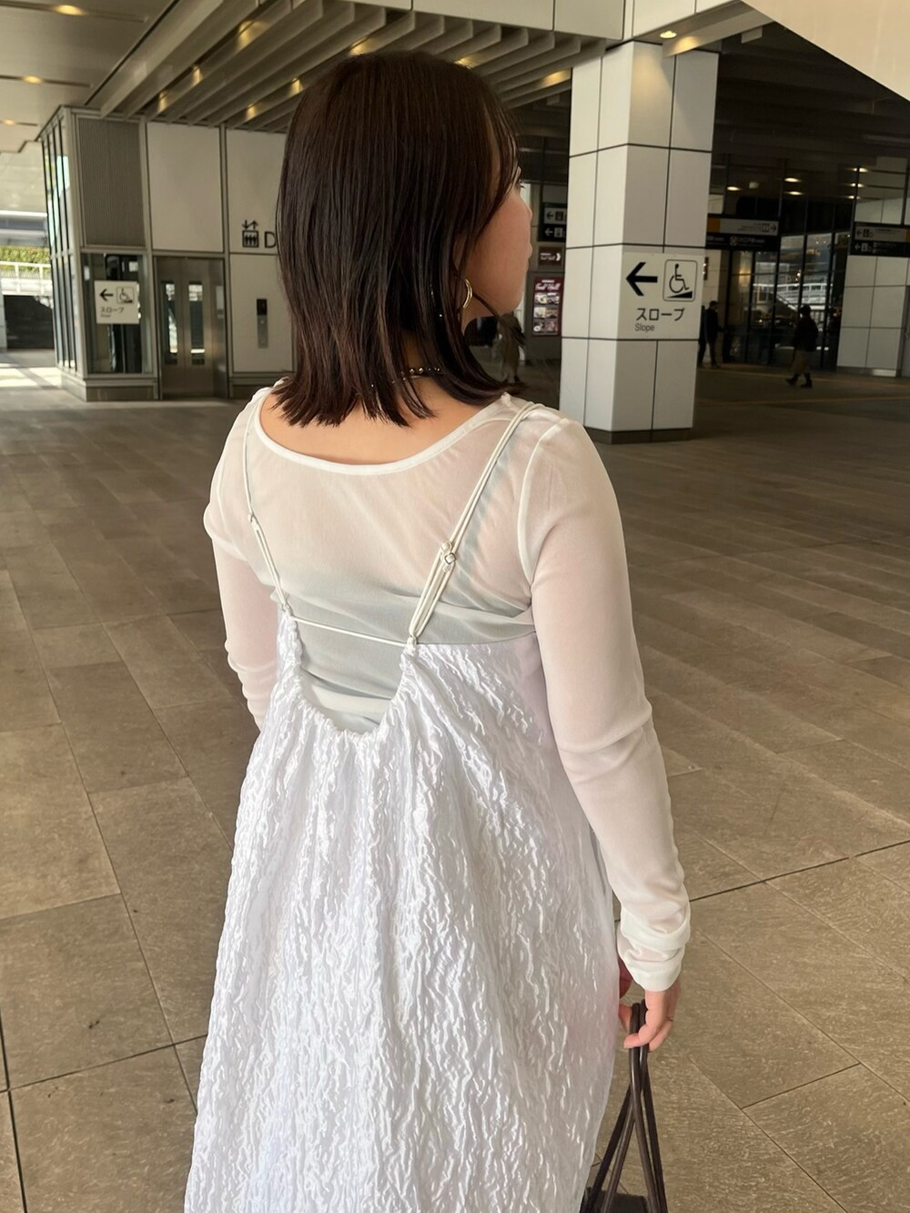 ホワイト系のTシャツ/カットソー、ホワイト系のワンピース、ホワイト系のブーツを着用したレディースの冬コーディネートの9枚目の写真