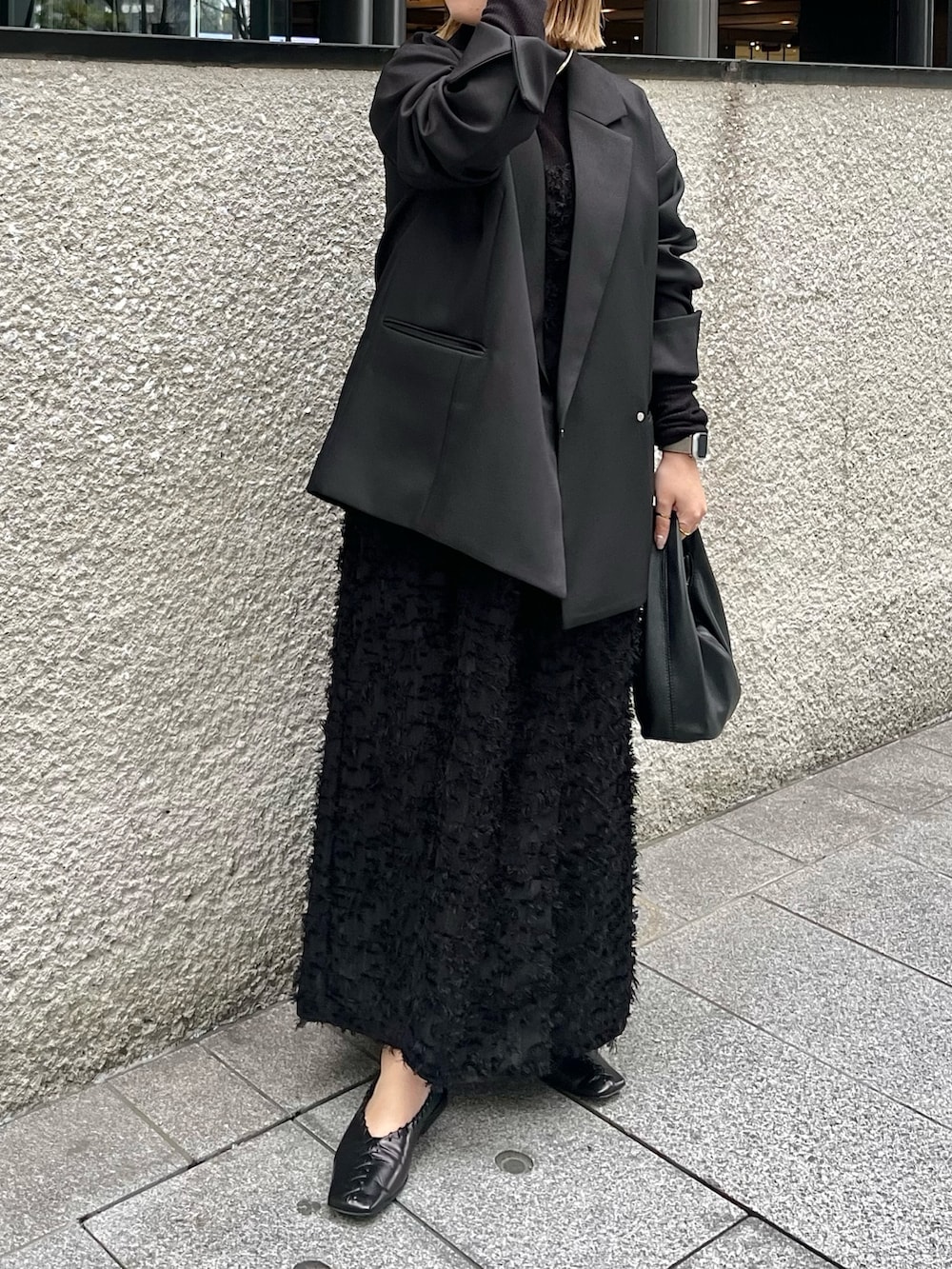 ブラック系のテーラードジャケット、ブラック系のニット/セーター、ブラック系のワンピースを着用したレディースの冬コーディネートの3枚目の写真