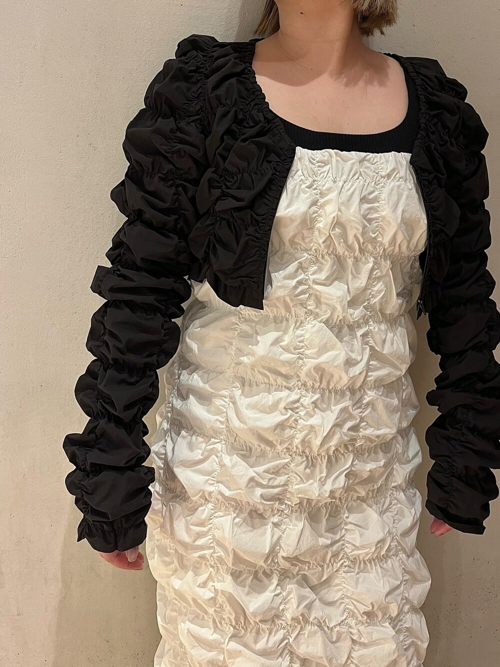 ホワイト系のワンピース、ブラック系のカーディガン/ボレロを着用したレディースの冬コーディネートの6枚目の写真