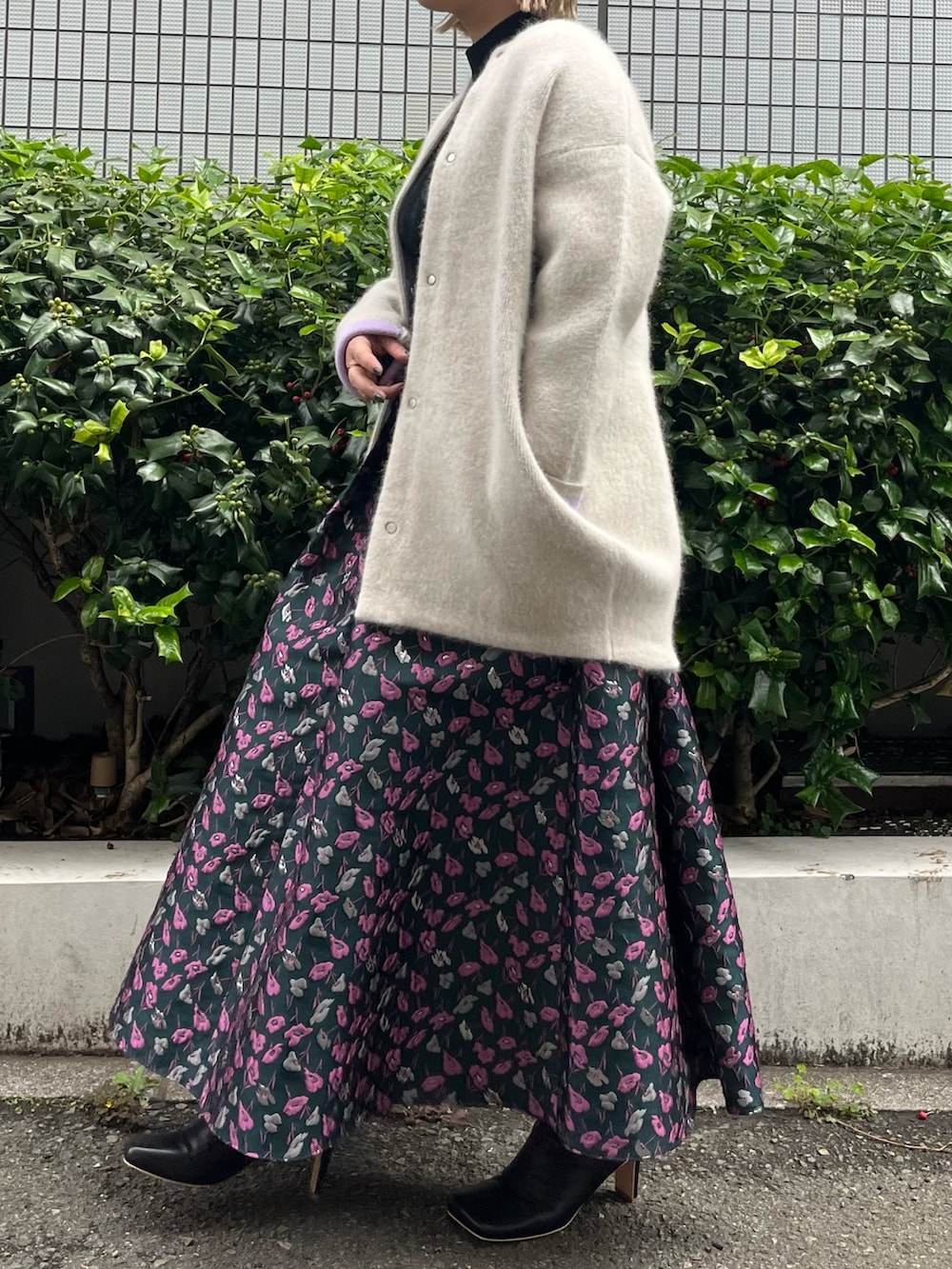 ホワイト系のノーカラージャケット、グリーン系のスカート、ブラック系のブーツを着用したレディースの夏コーディネートの2枚目の写真