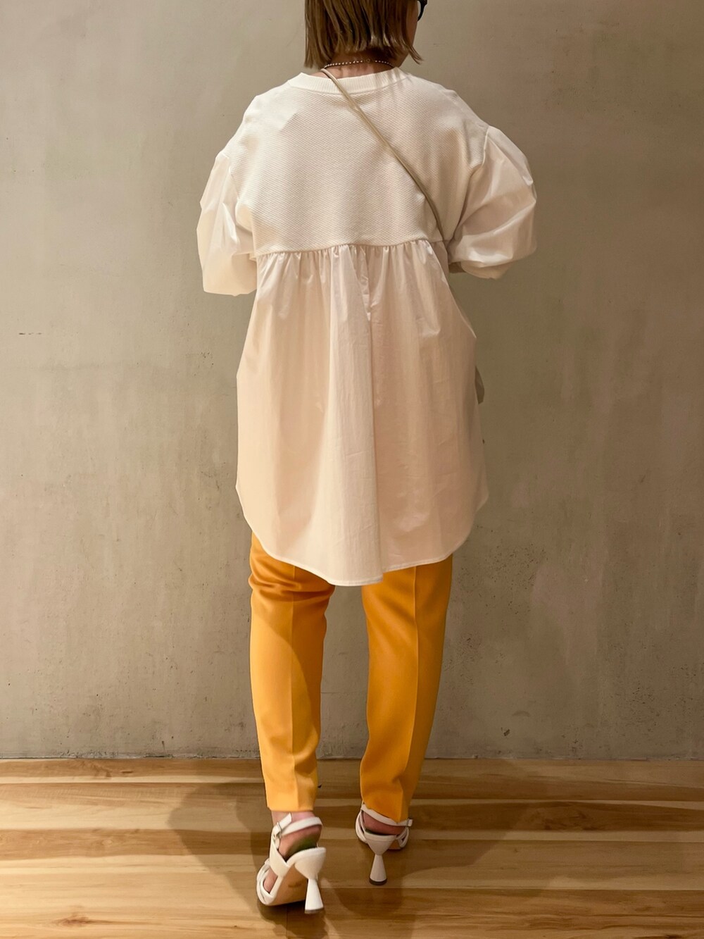 ホワイト系のシャツ/ブラウス、オレンジ系のその他パンツ、ホワイト系のサンダルを着用したレディースの冬コーディネートの3枚目の写真