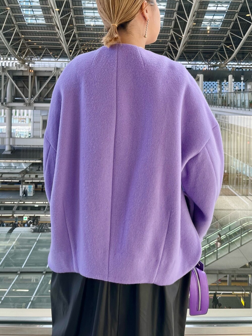 パープル系のノーカラージャケット、ブラック系のジャンパースカート、ホワイト系のニット/セーターを着用したレディースの秋コーディネートの7枚目の写真