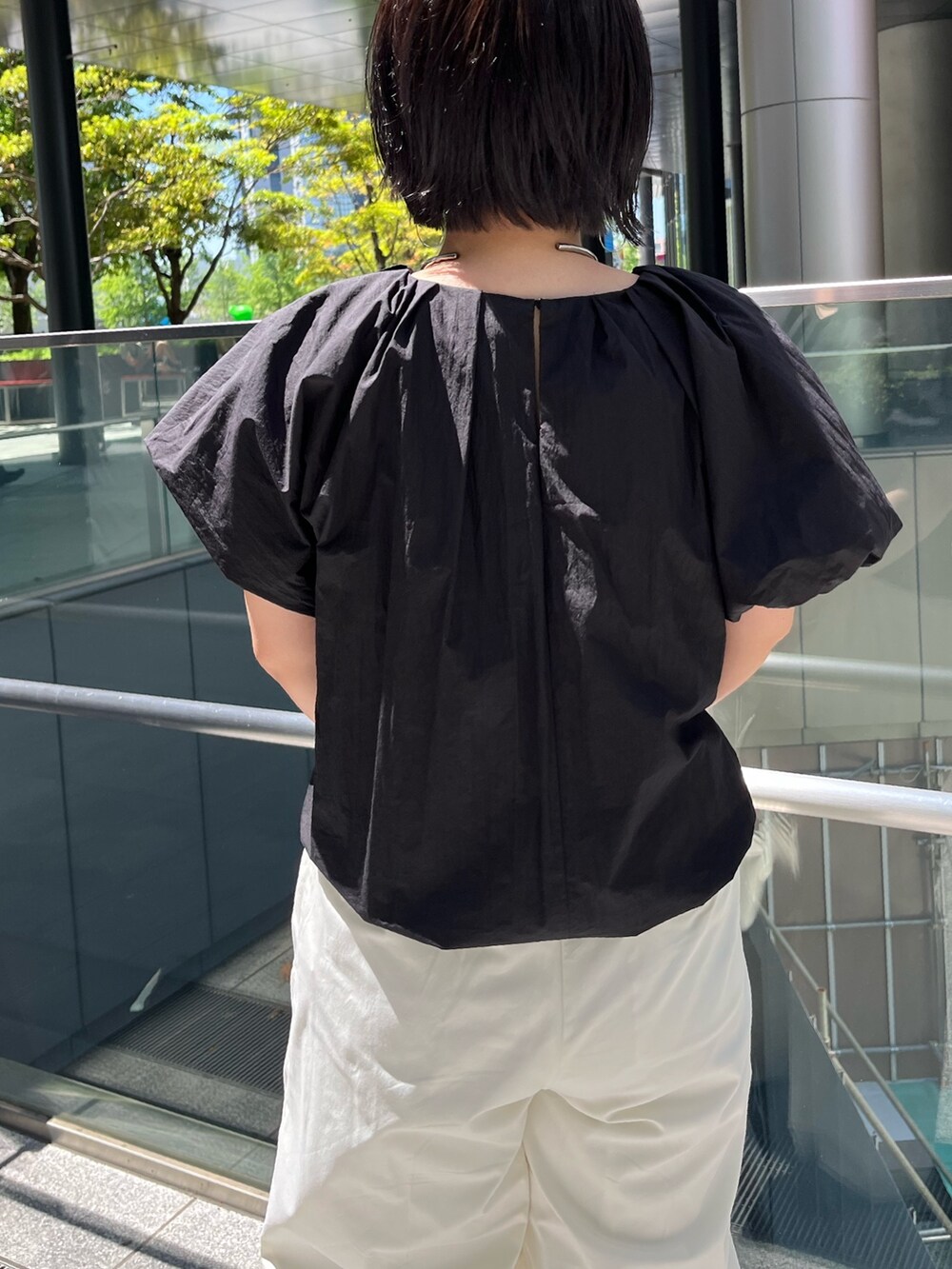 ブラック系のシャツ/ブラウス、ホワイト系のその他パンツ、ブラック系のサンダルを着用したレディースの春コーディネートの6枚目の写真