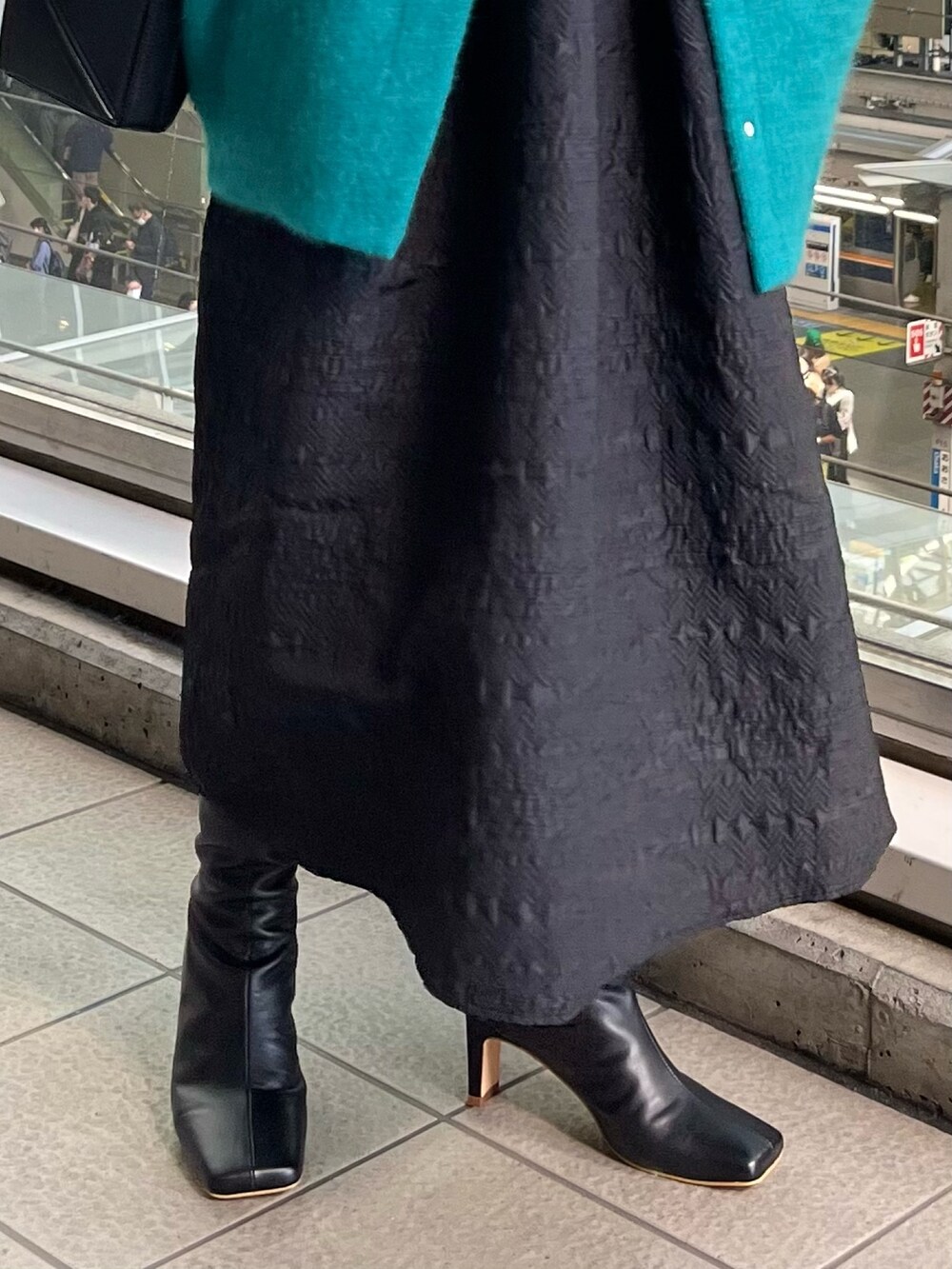 ブラック系のワンピース、ブラック系のハンドバッグ、グリーン系のカーディガン/ボレロを着用したレディースの秋コーディネートの9枚目の写真