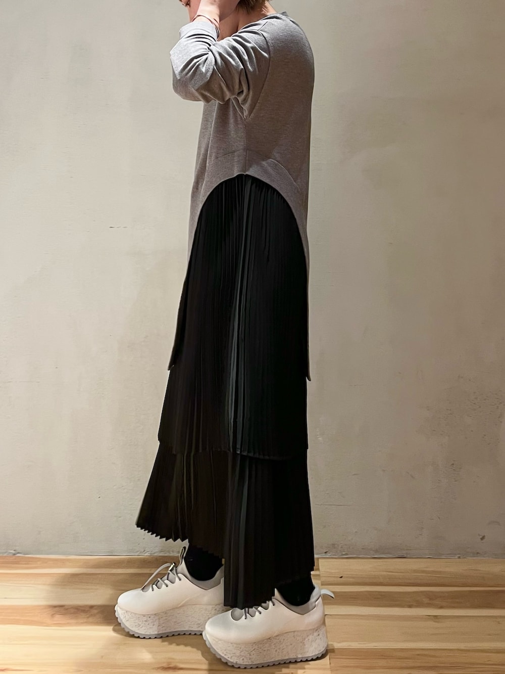 グレー系のワンピース、ホワイト系のスニーカー、ホワイト系のショルダーバッグを着用したレディースの冬コーディネートの10枚目の写真