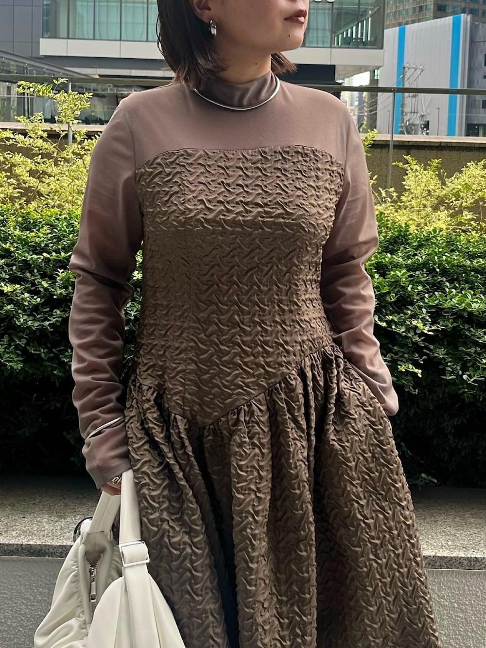 パープル系のカーディガン/ボレロ、ホワイト系のハンドバッグ、ベージュ系のワンピースを着用したレディースの夏コーディネートの9枚目の写真