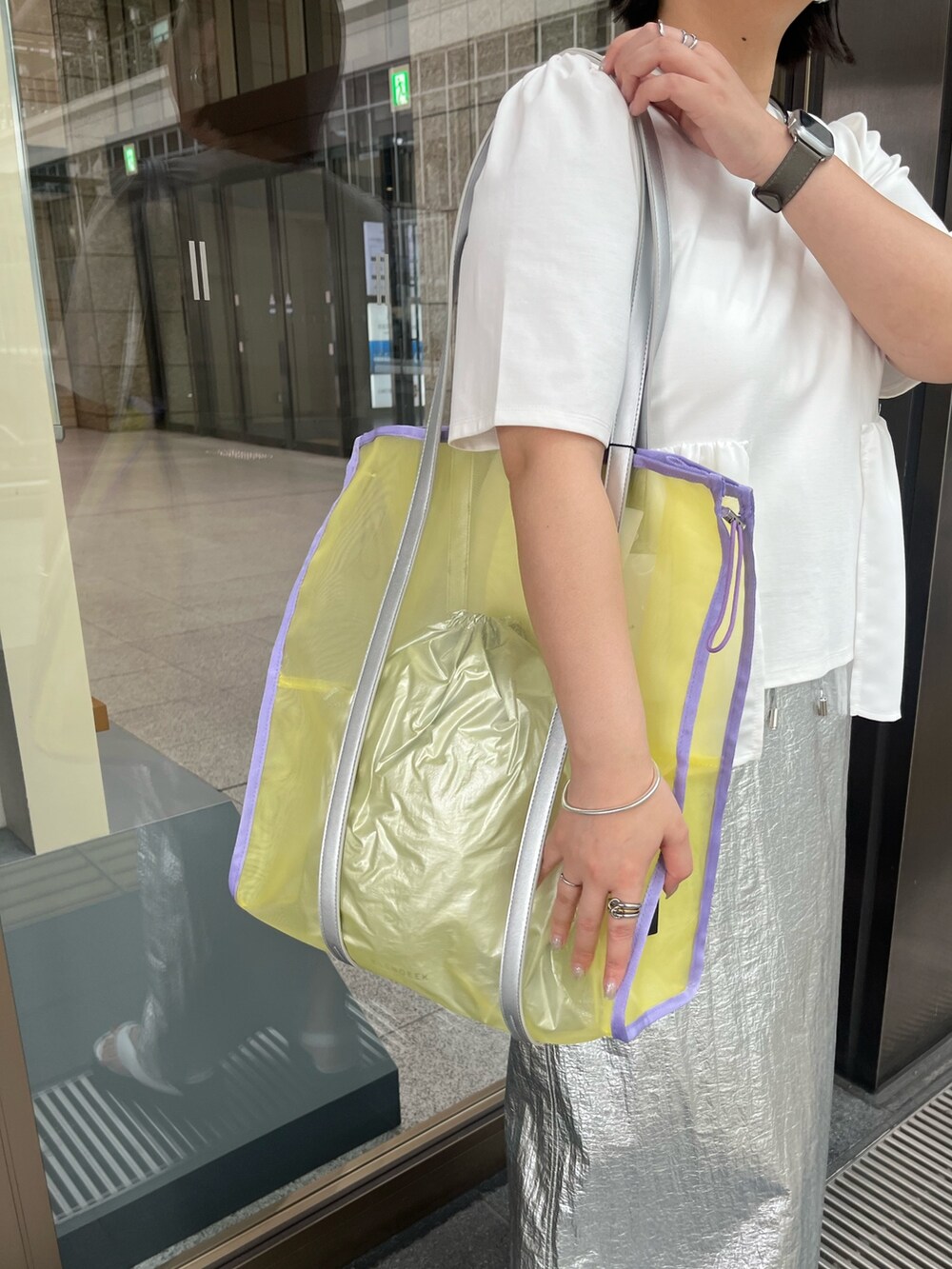 ホワイト系のTシャツ/カットソー、シルバー系のスカート、イエロー系のトートバッグを着用したレディースの春コーディネートの10枚目の写真