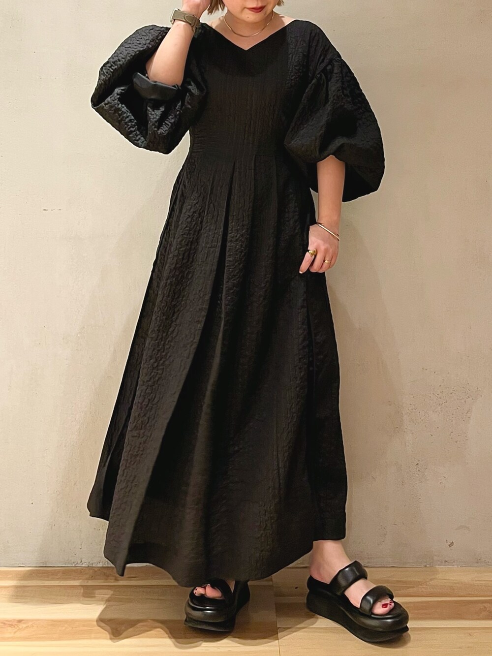 ブラック系のサンダル、ブラック系のワンピース、ゴールド系のネックレスを着用したレディースの冬コーディネートの4枚目の写真