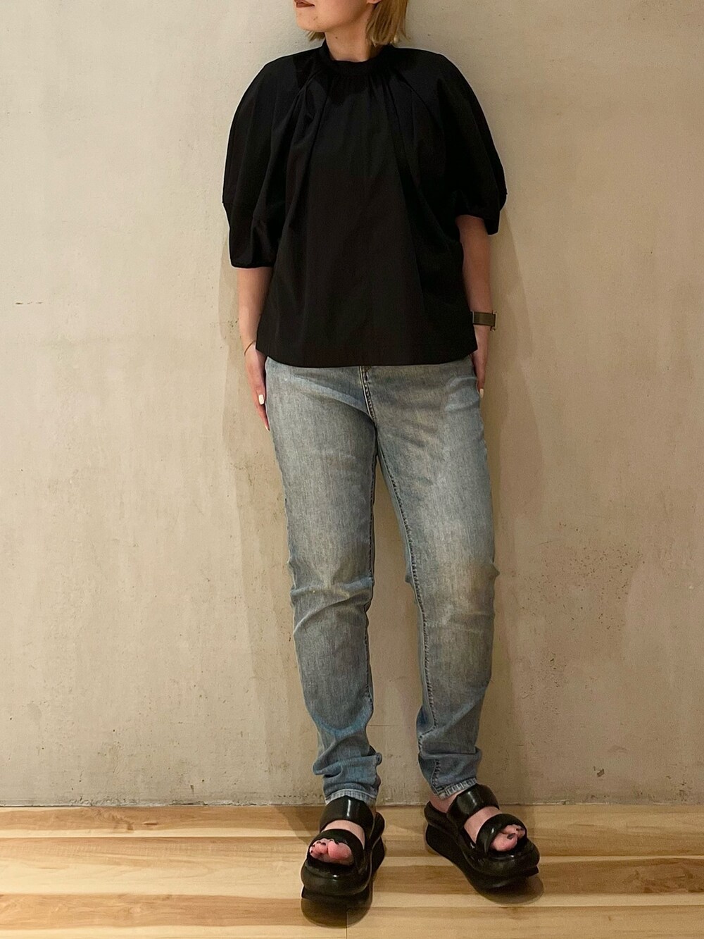 ブラック系のブルゾン、グリーン系のタンクトップ、ブルー系のデニムパンツを着用したレディースの夏コーディネートの5枚目の写真