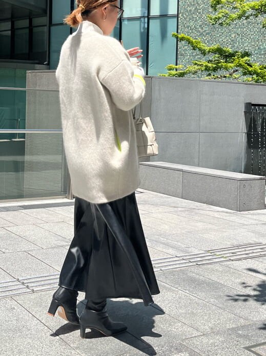 ブラック系のスカート、ホワイト系のニット/セーター、ホワイト系のカーディガン/ボレロを着用したレディースの夏コーディネートの4枚目の写真