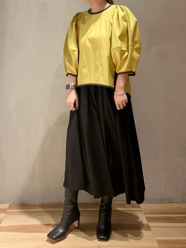 イエロー系のシャツ/ブラウス、ブラック系のスカート、ブラック系のブーツを着用したレディースの夏コーディネートの3枚目の写真