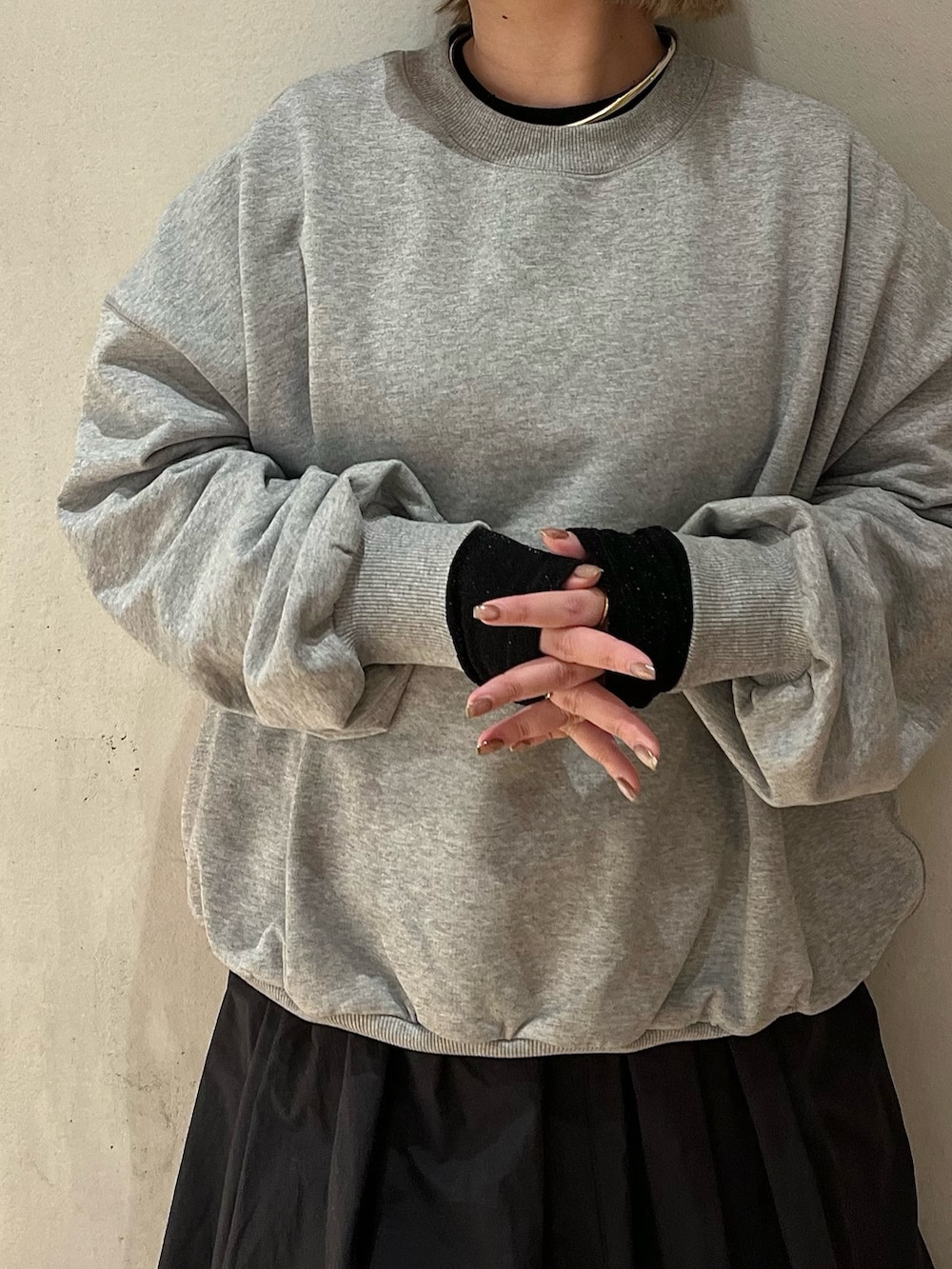 グレー系のスウェット、ブラック系のTシャツ/カットソー、ブラック系のスカートを着用したレディースの冬コーディネートの5枚目の写真