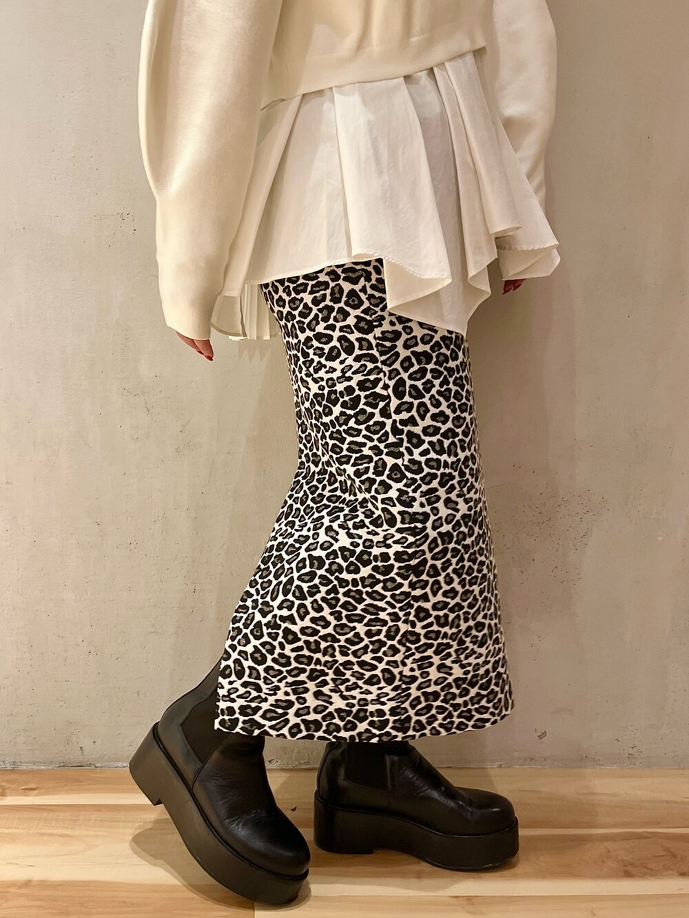 ホワイト系のスカート、ホワイト系のニット/セーター、ブラック系のショルダーバッグを着用したレディースの秋コーディネートの9枚目の写真