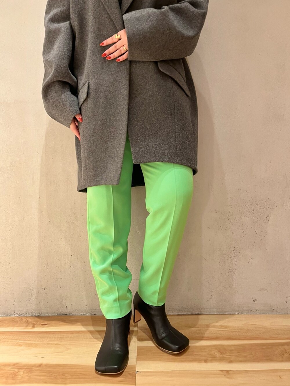 グレー系のチェスターコート、グリーン系のその他パンツ、シルバー系のTシャツ/カットソーを着用したレディースの秋コーディネートの7枚目の写真