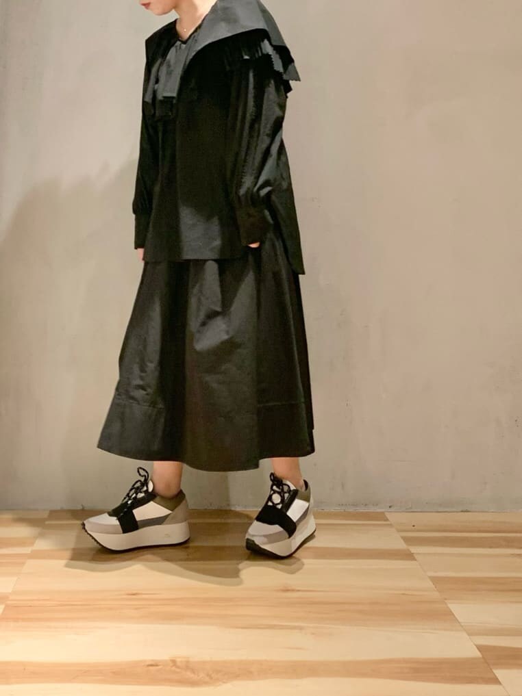 ブルー系のスニーカー、ブラック系のシャツ/ブラウス、ブラック系のスカートを着用したレディースの冬コーディネートの3枚目の写真