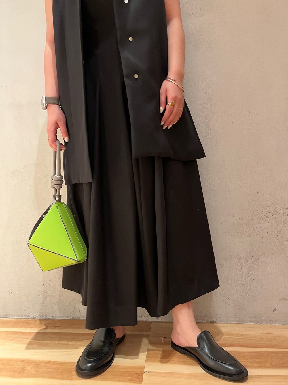 ブラック系のテーラードジャケット、ブラック系のワンピース、グリーン系のハンドバッグを着用したレディースの冬コーディネートの6枚目の写真